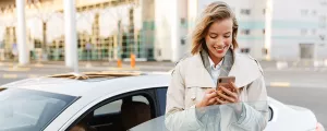Frau bezahlt Parkgebühr mit dem Handy